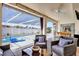 Relaxing covered patio with comfortable seating, bar, and a pool view at 9229 Water Hazard Dr, Hudson, FL 34667