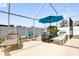 Screened-in patio with comfortable seating and a view of the backyard pool area at 9229 Water Hazard Dr, Hudson, FL 34667