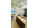 Bathroom featuring double sinks, a large mirror, and wooden cabinets with a window providing natural light at 1670 Monterey Dr, Clearwater, FL 33756