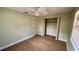 A bedroom with a ceiling fan, wood-look floors, and a closet for convenient storage at 1670 Monterey Dr, Clearwater, FL 33756