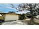 Charming home with stone accents, mature trees, attached two car garage, and landscaped front yard at 1670 Monterey Dr, Clearwater, FL 33756