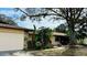 Charming single-Gathering home featuring a stone-accented facade, attached garage, and lush tropical landscaping at 1670 Monterey Dr, Clearwater, FL 33756
