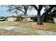 Charming home featuring a well-manicured front yard, mature trees, and an attached garage at 1670 Monterey Dr, Clearwater, FL 33756
