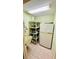 Well-lit laundry room with storage shelves, utility sink, and full-size refrigerator at 1670 Monterey Dr, Clearwater, FL 33756