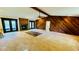 Open living room with stone fireplace and exposed wood beam and outdoor access at 1670 Monterey Dr, Clearwater, FL 33756