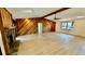 Bright living room with stone fireplace, wood accent wall, and new light wood flooring at 1670 Monterey Dr, Clearwater, FL 33756