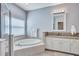 Elegant bathroom with soaking tub, glass enclosed shower, and dual sink vanity with granite countertop at 1778 Mira Lago Cir, Ruskin, FL 33570