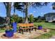 Relaxing park bench surrounded by trees and vibrant flower pots, creating a peaceful seating area at 2559 Stony Brook Ln, Clearwater, FL 33761