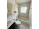 Bathroom with combination tub and shower, toilet, and built-in storage at 50 Acacia St, Clearwater Beach, FL 33767