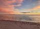 Seascape photo of a beach at sunset with tranquil waters and a colorful sky filled with pink clouds at 50 Acacia St, Clearwater Beach, FL 33767