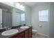 Bright bathroom featuring a double sink vanity with dark cabinets and a large mirror at 5249 Moon Shell Dr, Apollo Beach, FL 33572