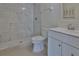 Bathroom featuring a walk-in shower with white marble tile and white vanity at 5729 13Th St, Zephyrhills, FL 33542