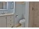 Updated bathroom features white vanity, toilet and tiled shower, all in a soothing blue palette at 5729 13Th St, Zephyrhills, FL 33542
