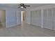 Bedroom with tile floors, ceiling fan, two closets and a view into the hallway at 5729 13Th St, Zephyrhills, FL 33542