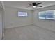 Cozy bedroom featuring tile floors, ceiling fan, and natural light from two windows at 5729 13Th St, Zephyrhills, FL 33542