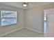 Bright bedroom with large window, ceiling fan, neutral paint, and tiled floors at 5729 13Th St, Zephyrhills, FL 33542