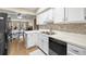 Bright kitchen with white cabinets, modern appliances, mosaic backsplash, and wood-look flooring at 7300 Sunshine Skyway S Ln # 202, St Petersburg, FL 33711