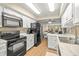 Modern kitchen with white cabinets, black appliances, and open layout to the living area at 7300 Sunshine Skyway S Ln # 202, St Petersburg, FL 33711
