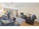 Bright living room with wood floors, large couch, tv, and access to a balcony at 7300 Sunshine Skyway S Ln # 202, St Petersburg, FL 33711