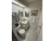 Bright bathroom featuring tile floors, a toilet, sink, and mirrored cabinet at 9337 Zamora Dr, New Port Richey, FL 34655