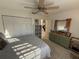 Bright bedroom with tile floor featuring a dresser, storage, closet, ceiling fan, and plush bed at 9337 Zamora Dr, New Port Richey, FL 34655