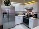 Well-equipped kitchen with stainless steel appliances, white cabinets, and counter appliances at 9337 Zamora Dr, New Port Richey, FL 34655