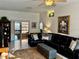 Spacious living room featuring tile floors, a ceiling fan, and a large black sofa at 9337 Zamora Dr, New Port Richey, FL 34655