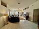 Open-concept living room with neutral tile flooring, featuring stylish decor and bright natural light at 9337 Zamora Dr, New Port Richey, FL 34655
