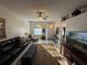 Bright living room featuring a comfortable leather sofa, ceiling fan, and lots of natural light at 9337 Zamora Dr, New Port Richey, FL 34655