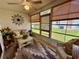 Enclosed patio view to exterior yard, ceiling fan, and wicker furniture at 9337 Zamora Dr, New Port Richey, FL 34655