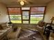 Enclosed lanai with ceiling fan, furniture and windowed views to exterior yard at 9337 Zamora Dr, New Port Richey, FL 34655