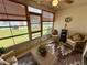 Enclosed sunroom with wicker furniture, ceiling fan, and large windows overlooking the lawn at 9337 Zamora Dr, New Port Richey, FL 34655