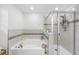 Bright bathroom showcasing a soaking tub and glass-enclosed shower with tiled surround at 11616 Little River Way, Parrish, FL 34219