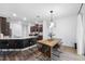Modern dining area with stylish lighting, a rustic table, and a view into the kitchen at 11616 Little River Way, Parrish, FL 34219