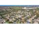 An aerial view of a quiet neighborhood featuring mature trees, well-maintained homes, and a nearby golf course at 1764 Oak Spring Dr, Tarpon Springs, FL 34689