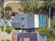 Aerial view of a home with a screened pool and solar panels at 1764 Oak Spring Dr, Tarpon Springs, FL 34689