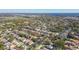 An aerial shot shows homes in a leafy neighborhood near green fields and a body of water under a clear sky at 1764 Oak Spring Dr, Tarpon Springs, FL 34689