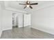 Spacious bedroom with tile flooring, ceiling fan, and direct access to ensuite bathroom and walk-in closet at 1764 Oak Spring Dr, Tarpon Springs, FL 34689