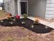 Close-up of the front yard landscaping with a variety of colorful plants and fresh mulch near the front door at 1764 Oak Spring Dr, Tarpon Springs, FL 34689