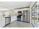Modern kitchen features white cabinets, stainless appliances, and view to screened porch at 1764 Oak Spring Dr, Tarpon Springs, FL 34689