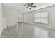 Bright living room featuring light gray floors, ceiling fan, and large window at 1764 Oak Spring Dr, Tarpon Springs, FL 34689