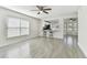 Bright and airy living room with durable tile flooring, ceiling fan, and a pass-through to the adjacent kitchen at 1764 Oak Spring Dr, Tarpon Springs, FL 34689