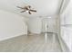 Bright living room features gray floors, ceiling fan, front door and staircase at 1764 Oak Spring Dr, Tarpon Springs, FL 34689