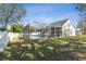 Wide shot of pool with screened enclosure, and green lawn at 1764 Oak Spring Dr, Tarpon Springs, FL 34689