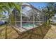 Exterior shot of the screened pool enclosure and landscaping at 1764 Oak Spring Dr, Tarpon Springs, FL 34689
