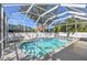 Pool and backyard views from inside the screened-in enclosure at 1764 Oak Spring Dr, Tarpon Springs, FL 34689