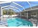 View of the home's in-ground pool, with screened-in enclosure and backyard at 1764 Oak Spring Dr, Tarpon Springs, FL 34689