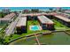 Aerial view of beachfront condos with a pool and private dock on the water at 19701 Gulf Blvd # 328, Indian Shores, FL 33785