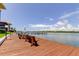 Waterfront view from a private dock with benches on the canal with a stunning blue sky at 19701 Gulf Blvd # 328, Indian Shores, FL 33785