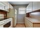 Efficient kitchen featuring white appliances, wood cabinets, and tile flooring at 19701 Gulf Blvd # 328, Indian Shores, FL 33785